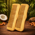 Two Bamboo hair combs on a wooden surface with coconuts and almonds in the background.