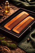 Two wooden combs in a black box with a bottle of oil and green fabric in the background. Smooth wooden hair comb for wet and dry hair detangling in Pakistan